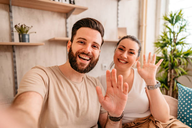 istock Smiling couple having video call at home 1329542000
