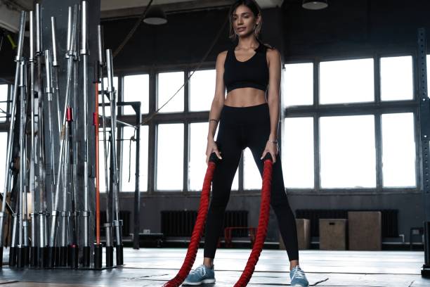 istock Young woman doing strength training using heavy ropes at the gym 1329543077