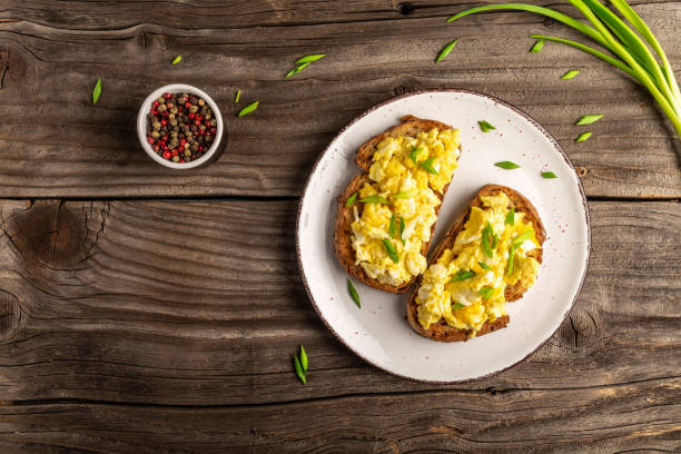 istock Breakfast with scrambled eggs on wholewheat toast. English breakfast with fried egg. banner, menu, recipe, place for text 1329543196