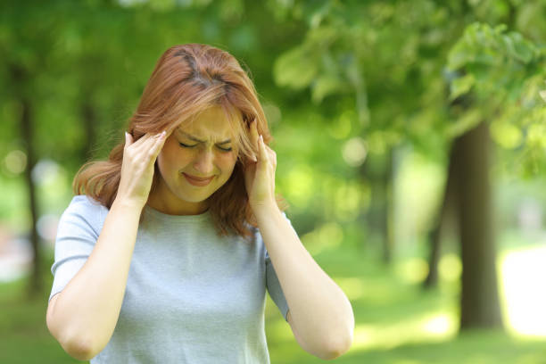 istock Woman suffering migraine attack in a park 1329543408