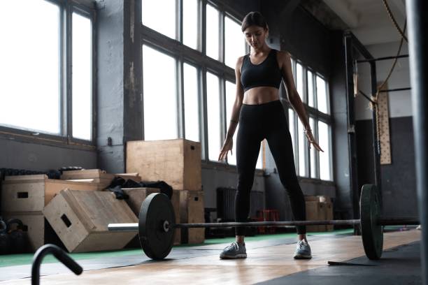 istock Attractive strong muscular female bodybuilder doing heavy duty squats lifting barbell at the gym gym. 1329543784