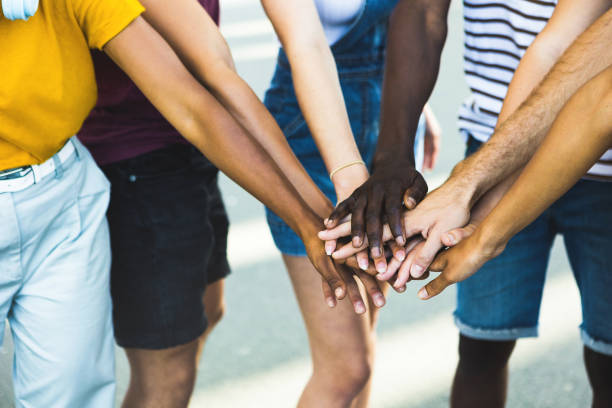 istock Close up multi ethnic group of young students stacking hands together - Millennial people celebrating together outdoor 1329544907