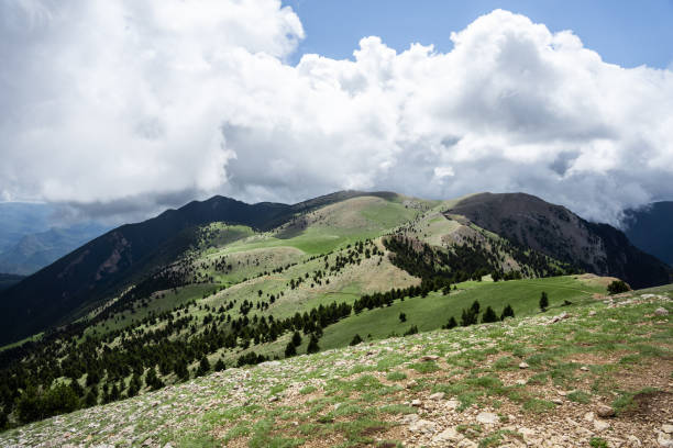 istock Beautiful mountain range with green grass and clouds 1329546153