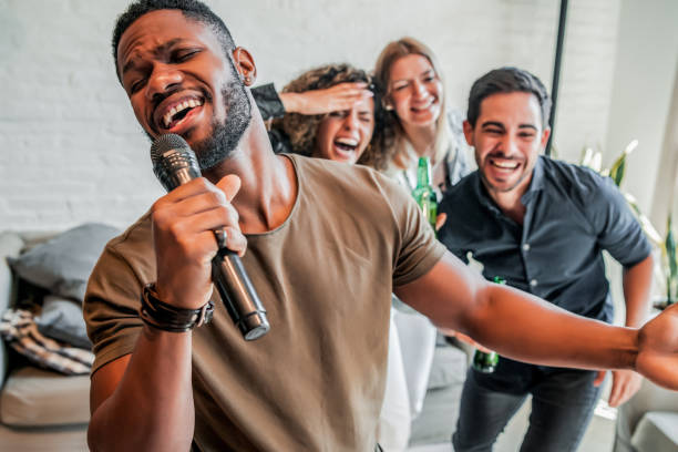 istock Group of friends playing karaoke at home. 1329546215