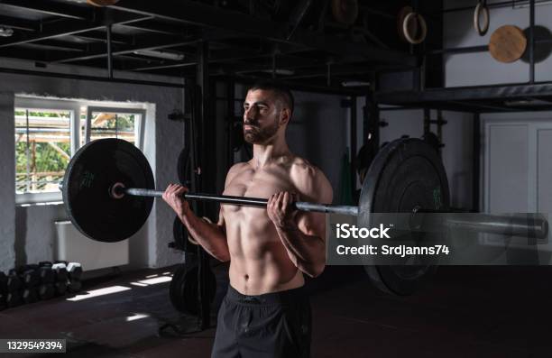 Young Active Sweaty Muscular Fit Strong Man With Big Muscles Doing Biceps Curly With Heavy Barbell Weight In The Gym As Hardcore Workout Cross Training Real People Exercise Stock Photo - Download Image Now