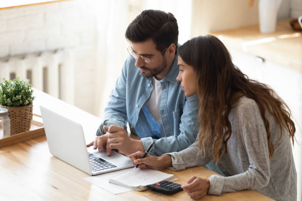 istock Couple looking at laptop screen analyzing expenses managing family budget 1329553192