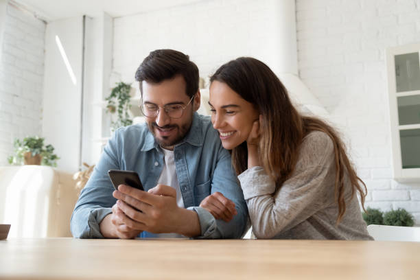 istock Couple looking at smartphone screen interested with ecommerce offer 1329553199
