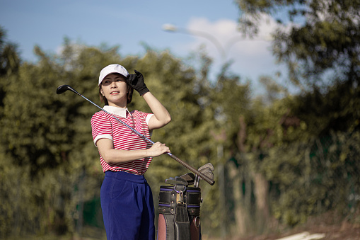 Asia Chinese woman golfer selecting driver club from golf bag and ready for her golf course