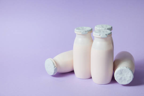 istock Bottles with probiotics and prebiotics dairy drink on light purple background. 1329560964