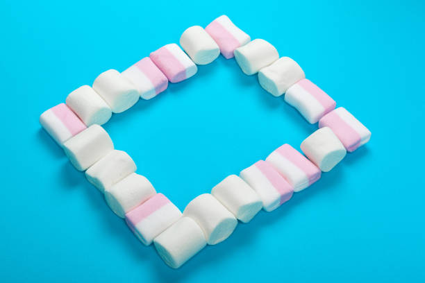 istock marshmallow laid out on blue paper background. pastel creative textured pattern. 1329561174
