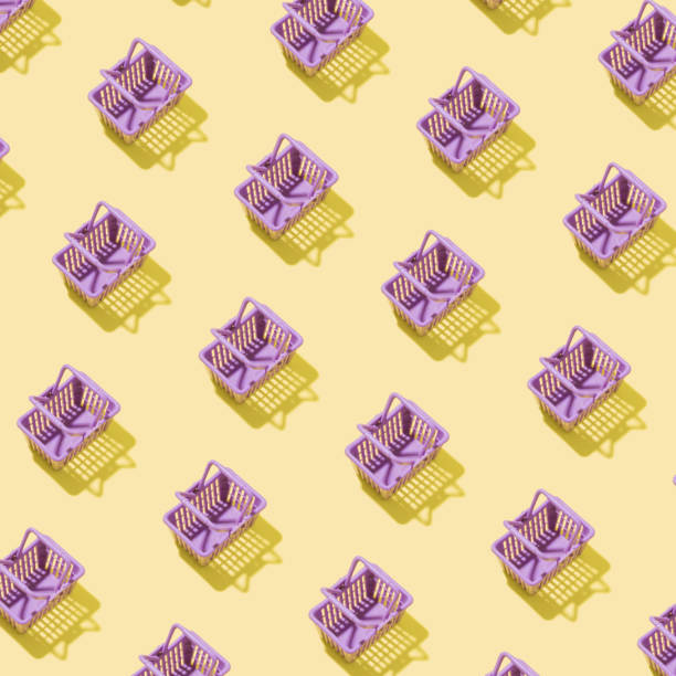 istock Pattern with miniature shopping basket in a supermarket on a yellow background. Minimalistic creative shopping concept 1329562987