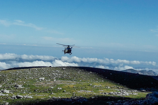 A helicopter flying over the National Park Covadonga, Asturias, Spain. Mountain rescue concept
