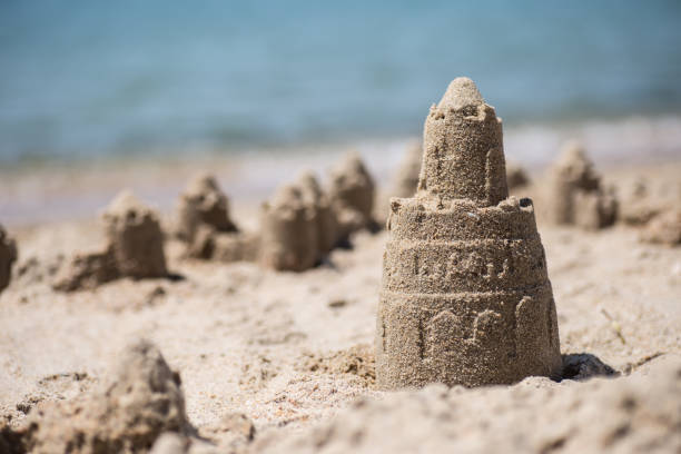 istock Sand castle standing on the beach. Travel vacations concept 1329566566