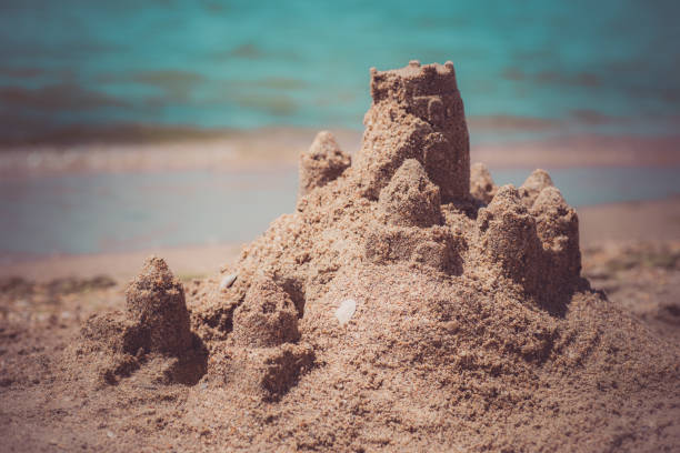 istock Sand castle standing on the beach. Travel vacations concept 1329566597