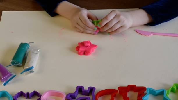 istock Toddler hands playing colorful play dough with plastic molds 1329567519