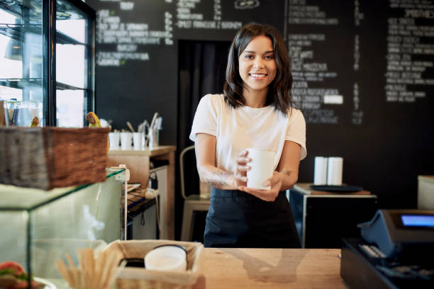 istock Smiling female barista serving takeaway coffee at cafe 1329568683