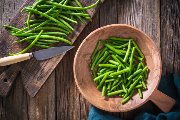 istock Green beans cut with knife on rustic wood table 1329568989