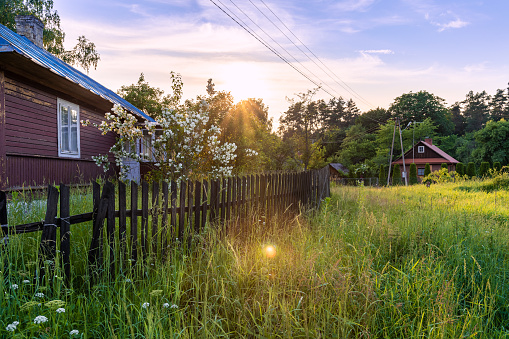Beautiful, traditional, polish village at the sunset. Old, wooden buildings next to green, fresh meadow. Idyllic countryside view. Krasnobród, Roztocze, Poland.