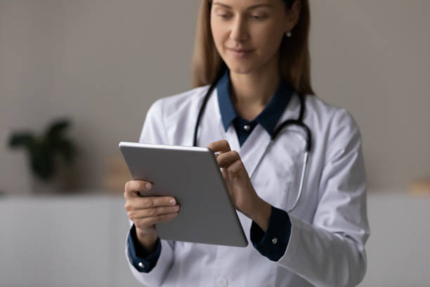istock Focused doctor, physician using tablet computer, giving online virtual consultation 1329569964