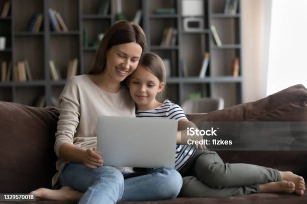 Happy Daughter Kid And Smiling Young Mom Using Laptop Stock Photo - Download Image Now