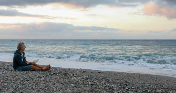 istock Man relaxes on Mediterranean beach at sunrise 1329570962