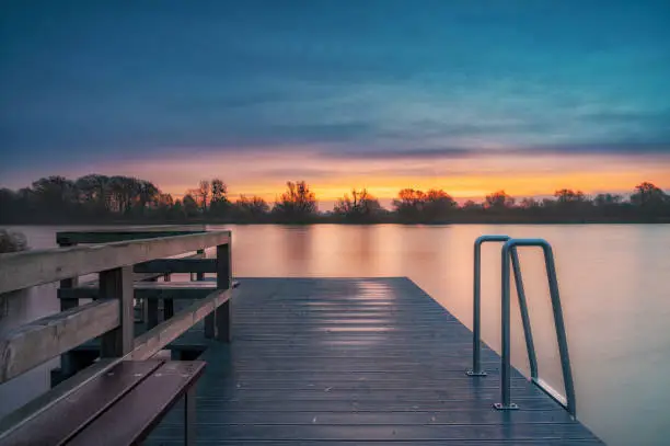 A sunrise on the lake that invites you to linger on the jetty.