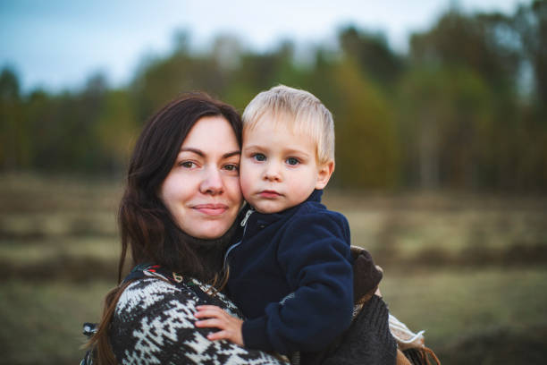 istock Mother and little son resting in autumn  park 1329573788