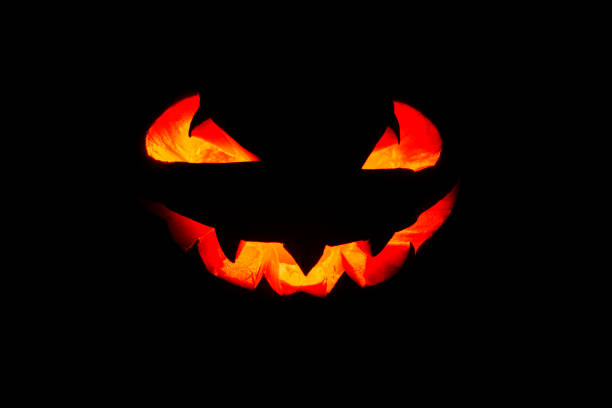 светящиес�я глаза и рот из тыквы хэллоуина (jack o lantern) на черном фоне. хеллоуин. - fire thanksgiving leaf burning стоковые фото и изображения