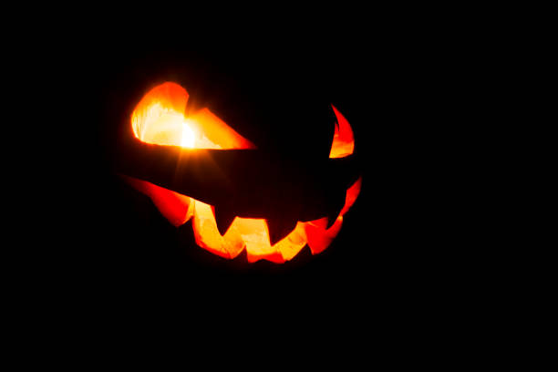 светящиеся глаза и рот из тыквы хэллоуина (jack o lantern) на черном фоне. хеллоуин. - fire thanksgiving leaf burning стоковые фото и изображения