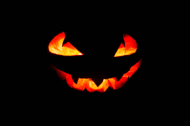 светящиеся глаза и рот из тыквы хэллоуина (jack o lantern) на черном фоне. хеллоуин. - fire thanksgiving leaf burning стоковые фото и изображения