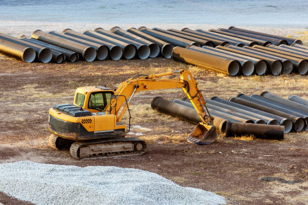 istock Yellow Excavator and Pipes - Tubes in construction site on sunset 1329573998