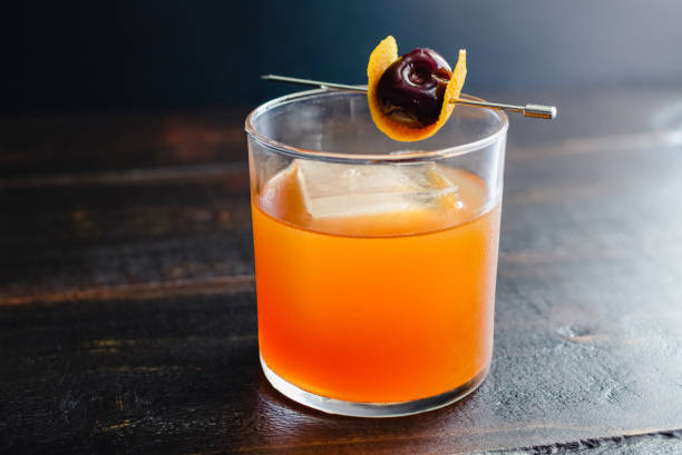 Maple Bourbon Cocktail with a Cherry Garnish A bourbon cocktail made with maple syrup and orange juice maraschino cherry stock pictures, royalty-free photos & images
