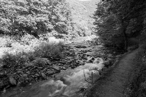 Black and white photo of the East Lyn river flowing through the Doone Valley at Watersmmeet in Devon