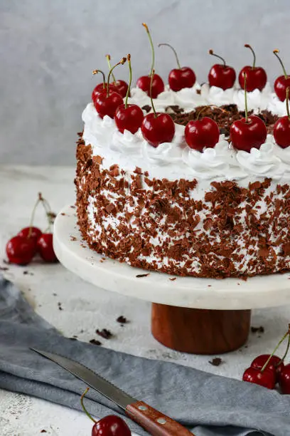 Stock photo showing an close-up view of a homemade, luxury, Black Forest gateau displayed against a marble effect background.