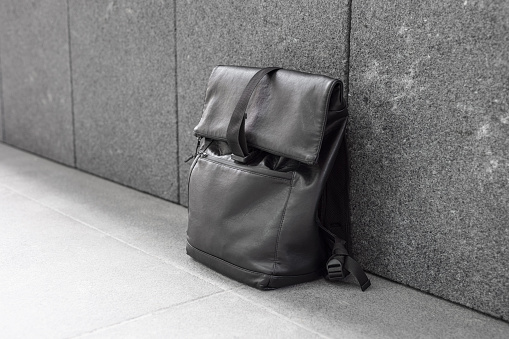 Black backpack near the grey wall