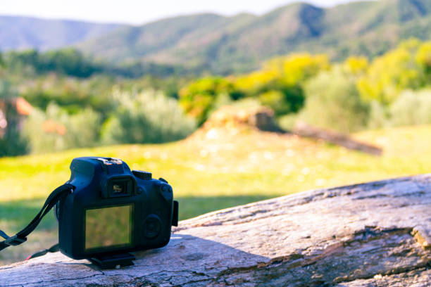istock professional camera on wooden surface blurred background of mountain. 1329588602