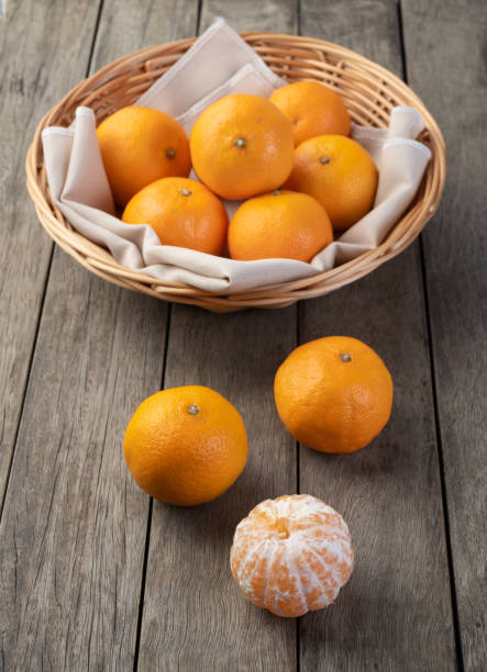 istock Mini tangerines in a basket over wooden table 1329592301