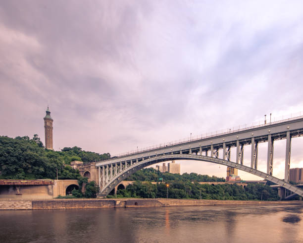 Wide horizontal view of the historic High Bridge spanning the Harlem River and Highbridge Water Tower is the distance. Bronx, NY - USA - July 17, 2021: Wide horizontal view of the historic High Bridge spanning the Harlem River and Highbridge Water Tower is the distance. harlem park stock pictures, royalty-free photos & images