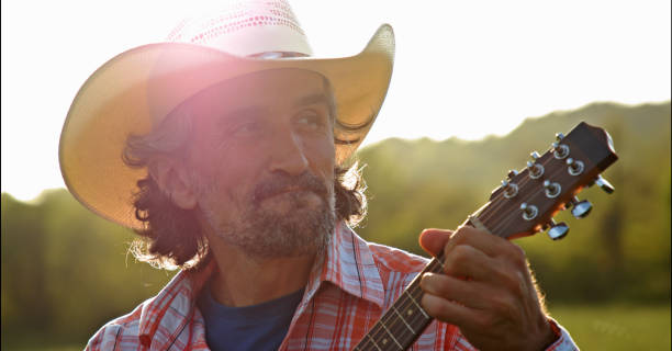istock Cowboy in nature playing the guitar at sunset. Springtime staycation. 1329596794