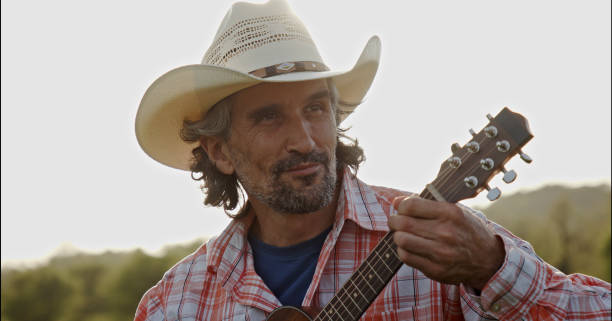 istock Cowboy in nature playing the guitar at sunset. Springtime staycation. 1329596796