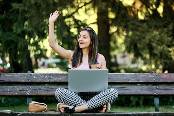 istock Young woman using laptop in the park 1329597302