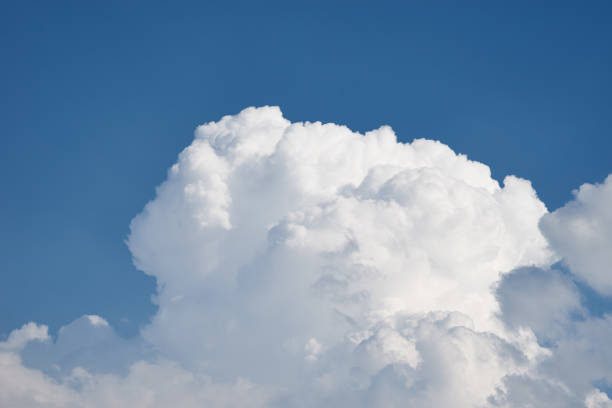 istock Close up of big white fluffy cloud on clear blue sky 1329602329