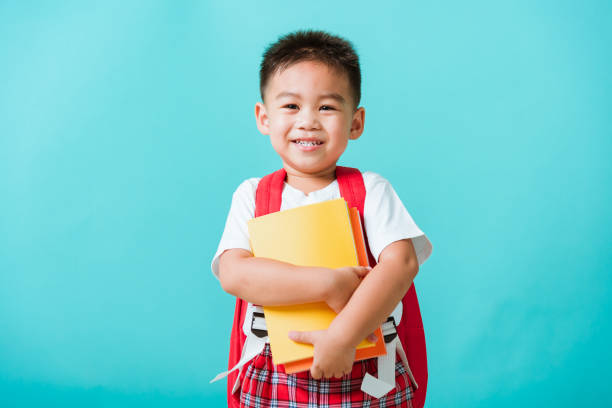 Kid from preschool kindergarten with book and school bag stock photo