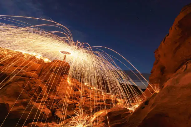 Showers of hot glowing sparks from spinning steel wool on the rock