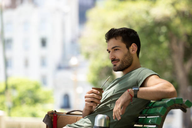 Young man drinking mate at Buenos Aires square stock photo