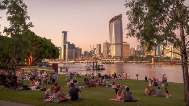 Picnics in South Bank, Brisbane Picnics on Riverside Green in South Bank, a recreational area in Brisbane, Australia, likely host of the 2032 Olympic Games. South Bank looks across the Brisbane River to the city skyline. brisbane photos stock pictures, royalty-free photos & images