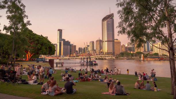 Picnics in South Bank, Brisbane Picnics on Riverside Green in South Bank, a recreational area in Brisbane, Australia, likely host of the 2032 Olympic Games. South Bank looks across the Brisbane River to the city skyline. natural parkland stock pictures, royalty-free photos & images