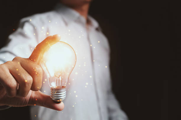 istock Businessman touching a bright light bulb. Concept of ideas for presenting new ideas Great inspiration and innovation new beginning. 1329608131