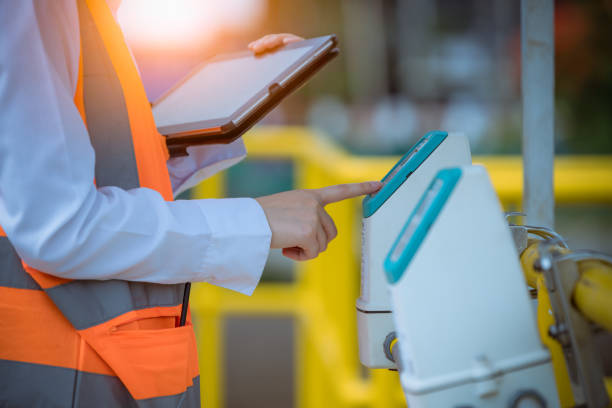istock Woker putting hand to control Cost-effective transmitter in waste water treatment pond system,check quality of water ,she wearing safety uniform in work. 1329614518
