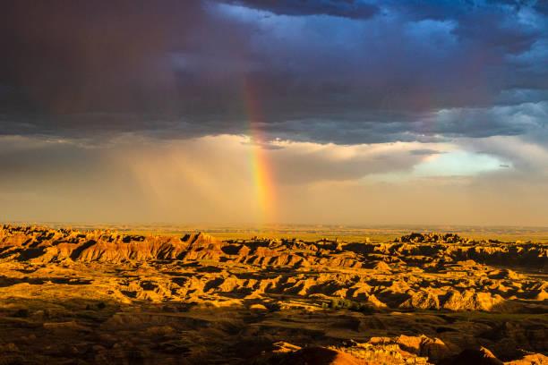istock Rainbow shining through stormy sky over golden desert landscape 1329614593